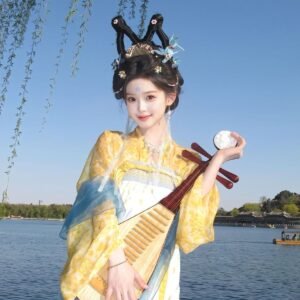 Young lady wearing Moon Laurel restored Tang Dynasty Qixiong Ruqun hanfu set, yellow chiffon hanfu with blue shawl holding pipa by lake
