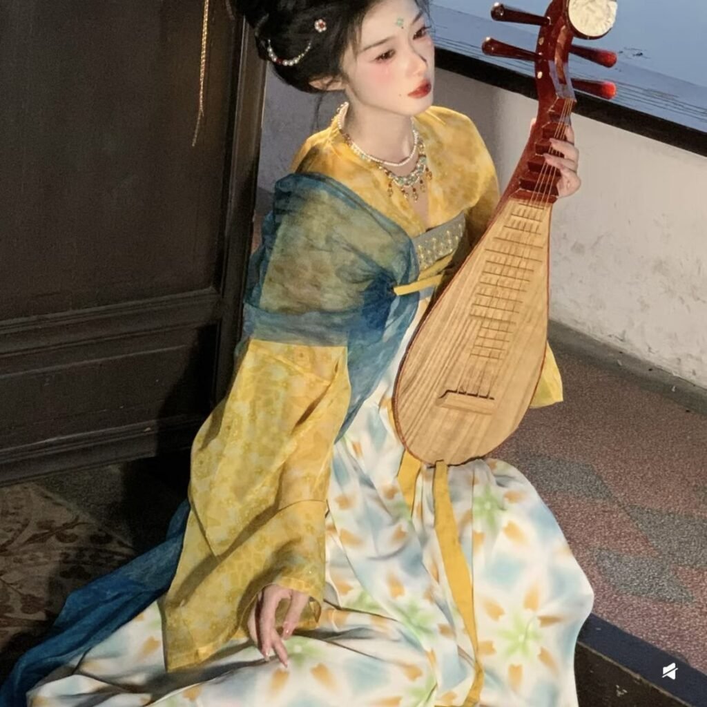 Young lady wearing Moon Laurel restored Tang Dynasty Qixiong Ruqun hanfu set, yellow chiffon hanfu with blue shawl holding pipa by lake