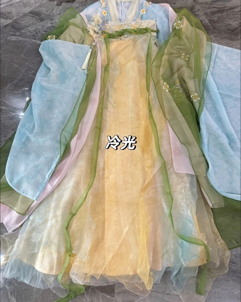 Young lady wearing Moon Laurel restored Tang Dynasty Qixiong Ruqun hanfu set, yellow chiffon hanfu with blue shawl holding pipa by lake